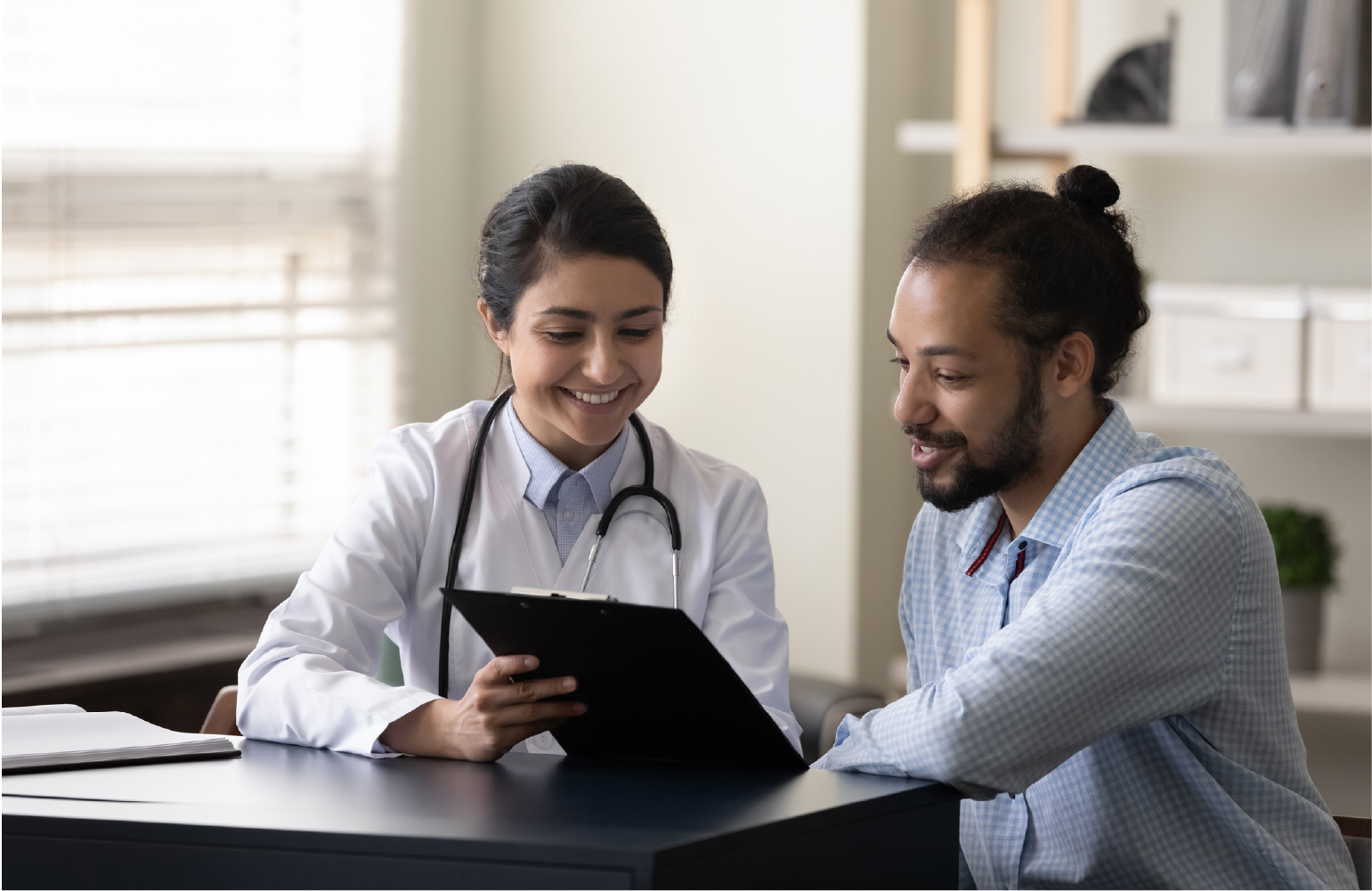 patient looking at an ipad with doctor at a desk